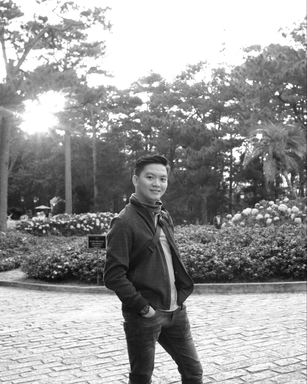 Quang Dang standing in a garden, hands in pockets